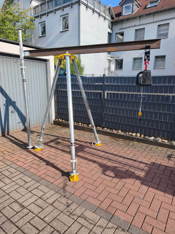 Bautri-Dreibein mit auskragendem Stahlträger und angehängtem Kettenzug im Freien aufgebaut