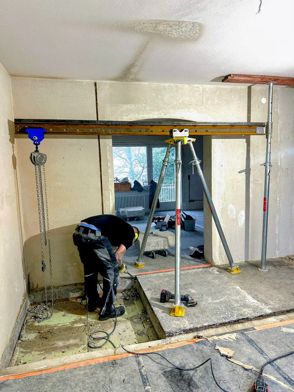 Bautri-Ausleger mit Stahlträger in einer Fensteröffnung im Rohbau
