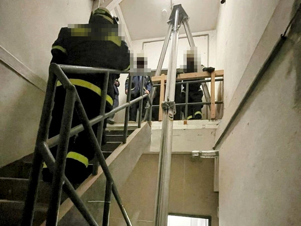 Bautri Rescue im Treppenhaus: Dreibein mit verlängertem Bein, ein Stockwerk tiefer – Übung, Personen unkenntlich gemacht
