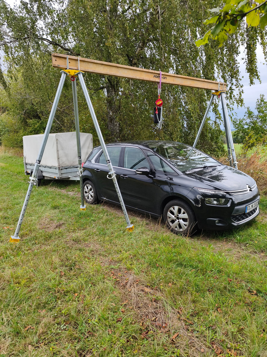 Portalhebung aus zwei Bautri-Dreibeinen mit Stahlträger – ein Auto passt darunter
